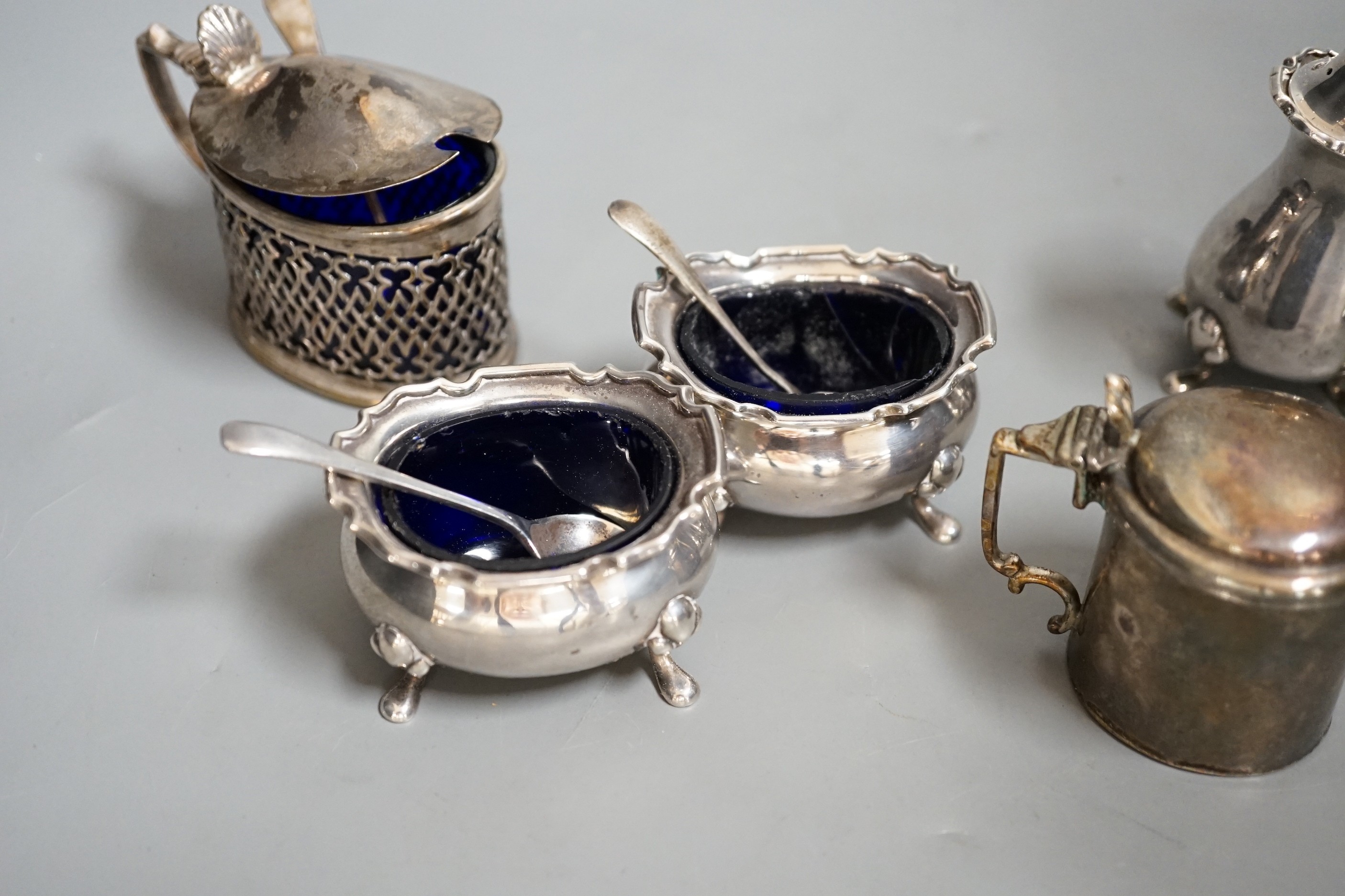 A George V silver four piece condiment set, Birmingham, 1922 and three other silver condiments.